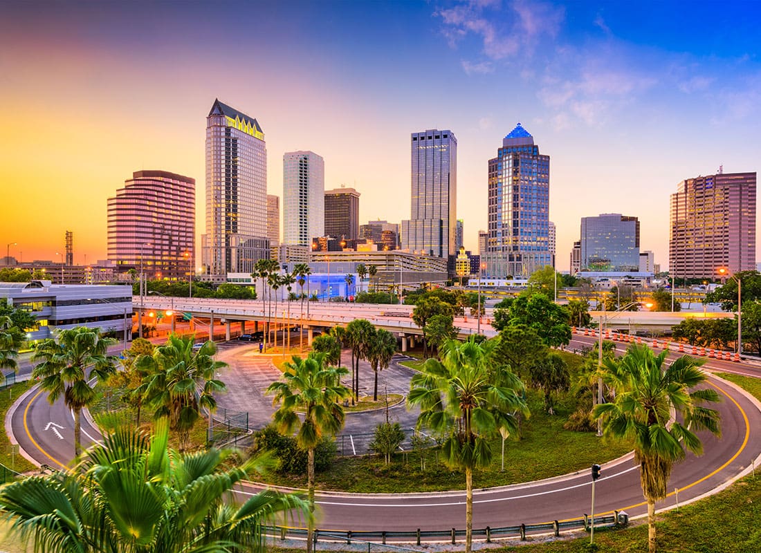 Tampa, FL - Scenic View of Modern Buildings Against a Colorful Sunset Sky in Tampa Florida Surrounded by Palm Trees