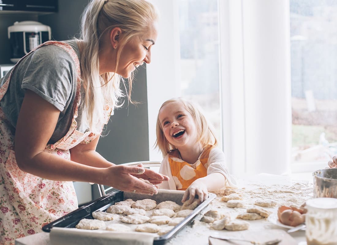 We Are Independent - Portrait of a Cheerful Grandmother Having Fun Baking Cookies with her Granddaughter in the Kitchen